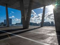 an open parking lot with sun shining through windows and a view of the city below