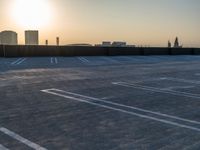 empty parking spaces in an industrial parking lot at sunset time with skyline in background,