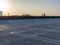 empty parking spaces in an industrial parking lot at sunset time with skyline in background,