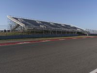 an empty track at a motorsports club with some red and white stripeing on it