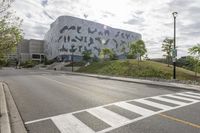 a large building with many designs on it's side in front of a road