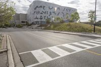 a large building with many designs on it's side in front of a road