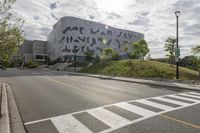 a large building with many designs on it's side in front of a road