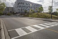 a large building with many designs on it's side in front of a road