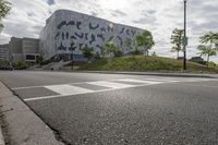 a large building with many designs on it's side in front of a road