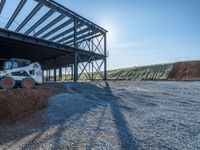 a picture of a building being built on a field near a forest in the background