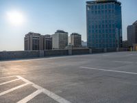 several large empty parking spaces in the city with buildings nearby in front of them -