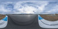 a fish eye view looking down at a skate park with people going to the other side of the ramp