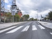 a street lined with traffic near a city ship on a cloudy day, with tall clouds