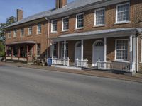 two story brick home with white pillars and columns with two front doors on a residential street