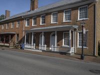 two story brick home with white pillars and columns with two front doors on a residential street