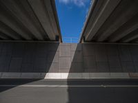 a person riding a skateboard across an overpass of a highway near the freeway