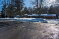 a snowy street in front of a lodge with a roof on it's side