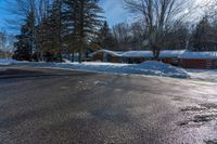 a snowy street in front of a lodge with a roof on it's side