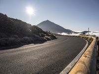 the road stretches down towards mountains with low clouds in front of it and on a clear day