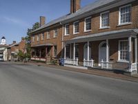 an old brick building sitting next to two rows of houses on a street with cars parked on it