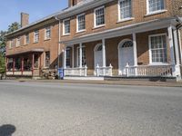 an old brick building sitting next to two rows of houses on a street with cars parked on it