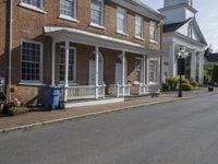 a street that has been paved with bricks and gravels on it and several windows that have white trimming