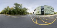 an empty city street has yellow lines on the side of it and traffic is shown in this fisheye image