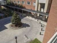 the top view of a building showing a courtyard and two benches with a tree on either side