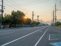 an empty street in front of a large red brick building on the other side of the road is a street light that has a line for motorists