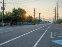 an empty street in front of a large red brick building on the other side of the road is a street light that has a line for motorists