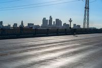 the sun is shining down over a highway with city buildings in the distance and blue skies