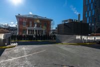 a small parking lot with no cars in front of a building and a fenced off street area