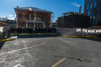 a small parking lot with no cars in front of a building and a fenced off street area