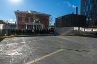 a small parking lot with no cars in front of a building and a fenced off street area