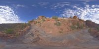 a view from a fish eye lens, of the red rocks and blue sky above