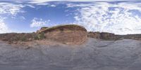 a view from a fish eye lens, of the red rocks and blue sky above