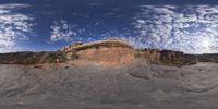 a view from a fish eye lens, of the red rocks and blue sky above