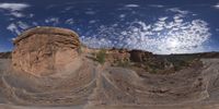 a view from a fish eye lens, of the red rocks and blue sky above