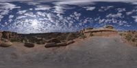 a view from a fish eye lens, of the red rocks and blue sky above