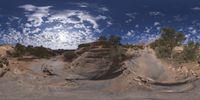 a view from a fish eye lens, of the red rocks and blue sky above