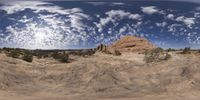 a view from a fish eye lens, of the red rocks and blue sky above