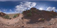 a view from a fish eye lens, of the red rocks and blue sky above