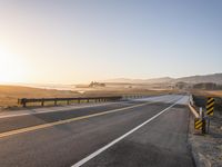 Sunrise on the Yellow Horizon: Asphalt Road Stretching into the Distance