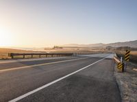 Sunrise on the Yellow Horizon: Asphalt Road Stretching into the Distance