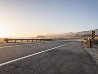 Sunrise on the Yellow Horizon: Asphalt Road Stretching into the Distance