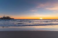 a beach scene during sunrise with the water still up to the ground and the ocean in the background