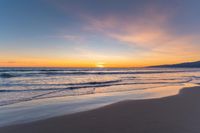 a beach scene during sunrise with the water still up to the ground and the ocean in the background