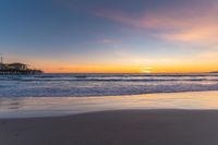 a beach scene during sunrise with the water still up to the ground and the ocean in the background