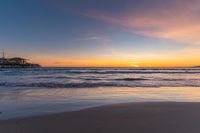 a beach scene during sunrise with the water still up to the ground and the ocean in the background