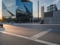 a man on his bike is passing by a building in a city intersection with cars