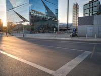 a man on his bike is passing by a building in a city intersection with cars