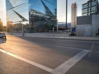 a man on his bike is passing by a building in a city intersection with cars