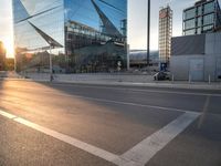 a man on his bike is passing by a building in a city intersection with cars