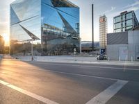 a man on his bike is passing by a building in a city intersection with cars